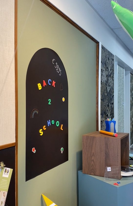 Tableau noir en forme d'arche avec lettres magnétiques 'BACK 2 SCHOOL' et décorations.