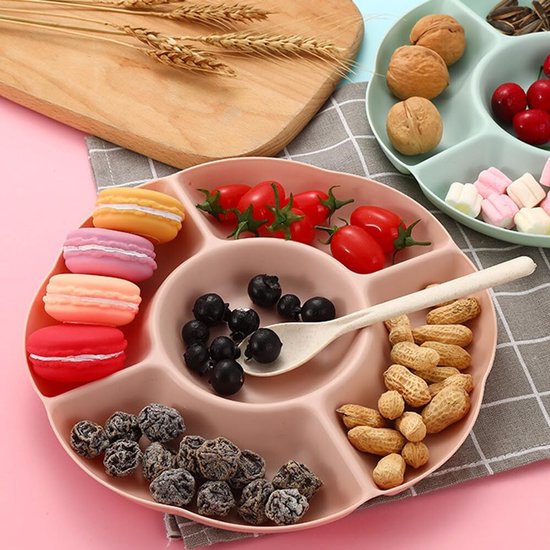 Roze snackbord met macrons, kerstomaatjes, bessen, pinda's en een schepje.