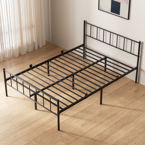 Cadre de lit en métal noir avec tête de lit, vu sous un angle, sur un parquet.
