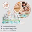Een babygym met zachte speeltjes en een mat met zeedieren. Een vrouw speelt met een baby op de mat. Iconen tonen sensorisch speelgoed.