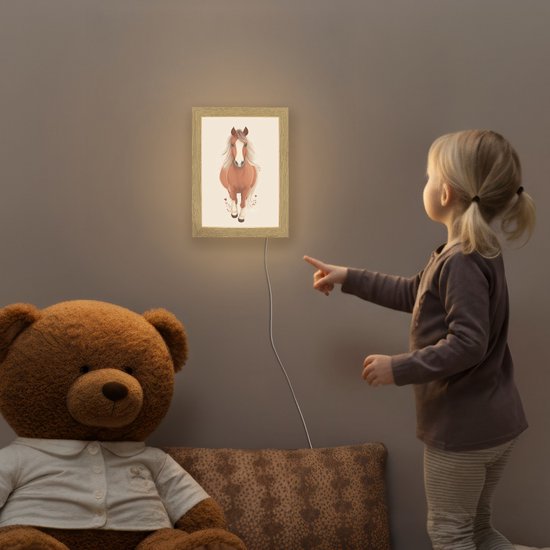 Meisje wijst naar een bruin paard nachtlampje in een kinderkamer met teddybeer.