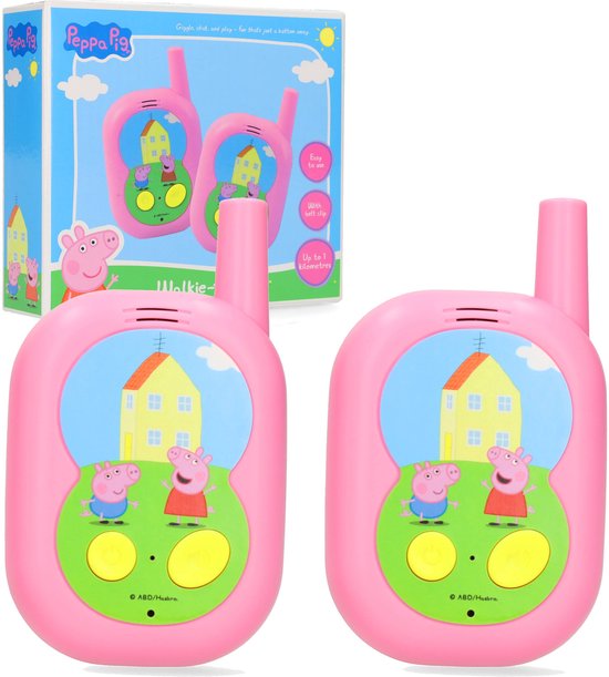 Roze Peppa Pig walkie-talkies met Peppa en George op een groen veld voor een geel huis. Verpakt in een doos met Peppa Pig logo.