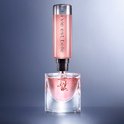 Een navulbare fles "La Vie est Belle" wordt in een glazen parfumfles gegoten.
