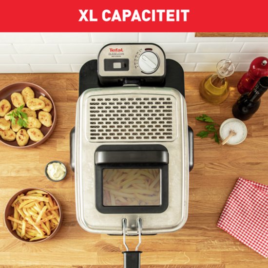 Bovenaanzicht van een RVS frituurpan met deksel, gevuld met frietjes. Naast de pan staan schaaltjes met snacks en frietjes, en olie.