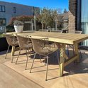 Houten tuintafel met zes beige stoelen met ribbelpatroon, op een houten terras onder de zon.