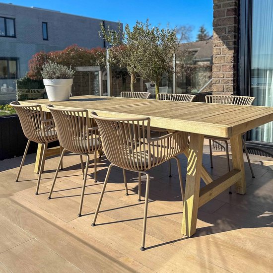 Houten tuintafel met zes beige stoelen met ribbelpatroon, op een houten terras onder de zon.