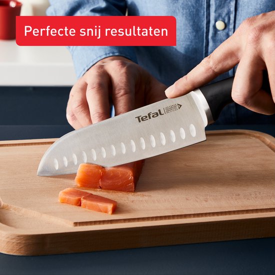 Hand snijdt zalm met Tefal koksmes op snijplank