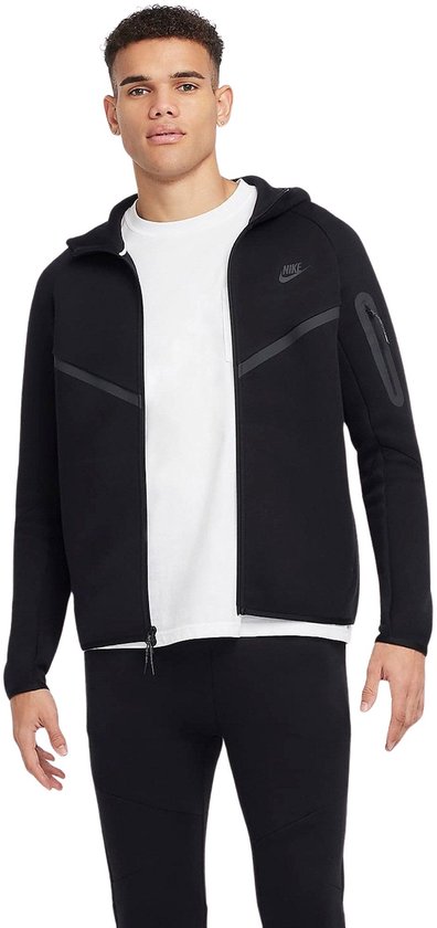 Man met witte t-shirt en zwarte Nike Tech Fleece hoodie, met rits en zakken.