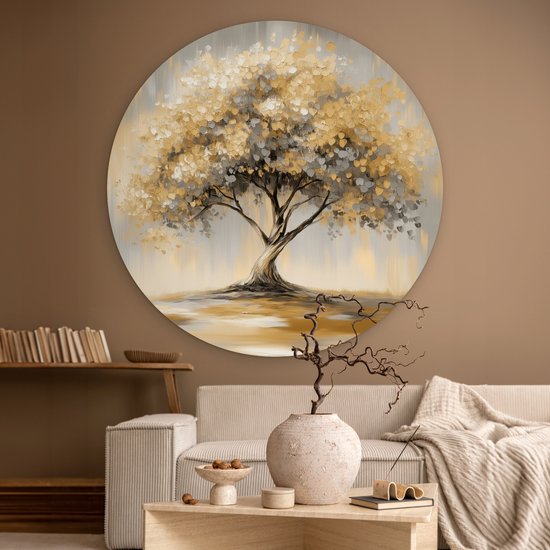 Ronde schilderij van een abstracte boom met gouden en grijze bladeren, boven een bank in een woonkamer.