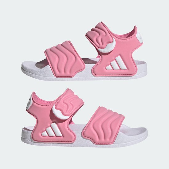 Twee roze Adidas kinder sandalen met witte golvende banden en drievoudig Adidas logo.