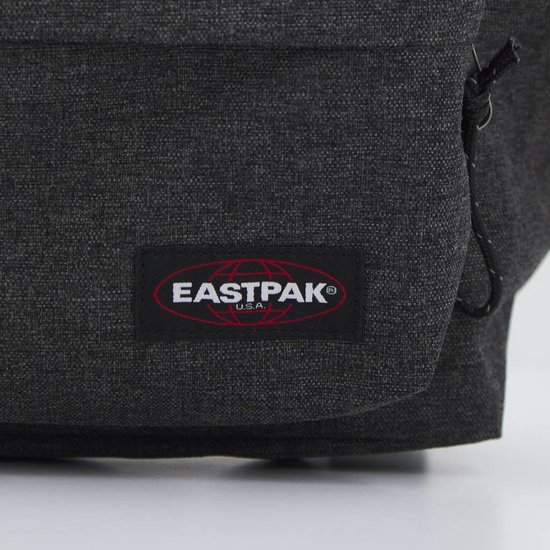 Close-up van het rode Eastpak logo op een donkergrijze rugzak in denimlook.