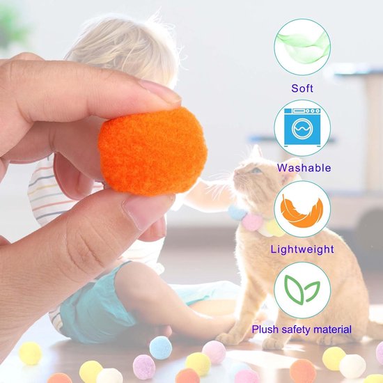 Hand houdt een zachte, wasbare en lichte oranje pomponbal vast. Kat met ketting van pompons.