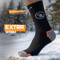 Zwarte thermosok met oranje en grijze versterking bij de hiel, in besneeuwde omgeving. "EXTRA WARM"