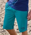 Gedetailleerde weergave van een groenblauwe heren bermuda met een contrasterende zijstreep en "Sport Team" logo.