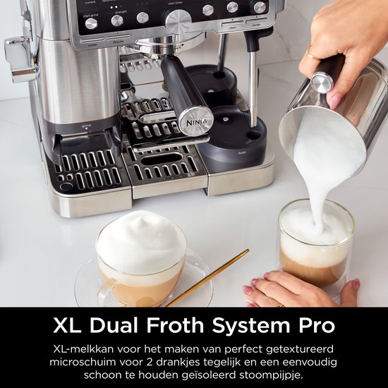 Een zilverkleurige melkopschuimer met XL Dual Froth System Pro wordt gebruikt om melkschuim in twee glazen te gieten.