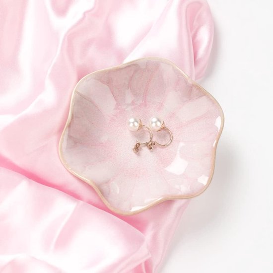 Roze keramische schaal met marmerpatroon met twee parelmoer oorbellen en gouden haakjes.