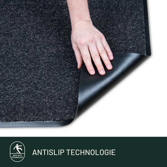 Grijze deurmat met een zichtbare antislip onderkant, door een hand wordt de mat opgetild.