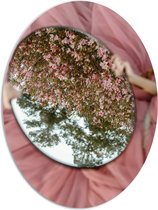 PVC Schuimplaat Ovaal - Bloesemstruik in Spiegel in Handen van Vrouw in Roze Jurk - 72x96 cm Foto op Ovaal (Met Ophangsysteem)