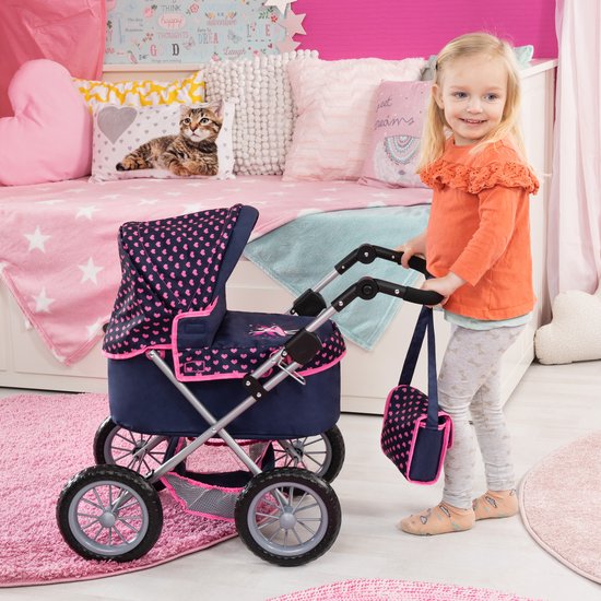 Meisje duwt een donkerblauwe poppenwagen met roze hartjespatroon in een kinderkamer.