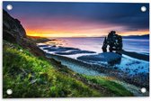 Tuinposter – Enorme Rots in de Zee bij de Bergen tijdens Zonsondergang - 60x40 cm Foto op Tuinposter (wanddecoratie voor buiten en binnen)