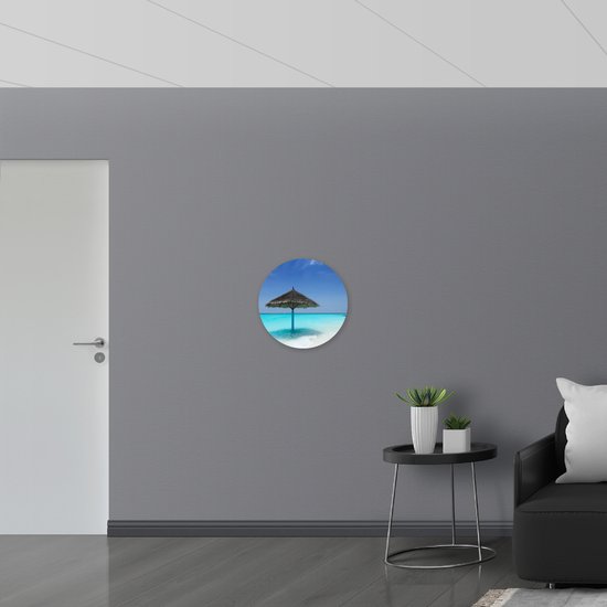 Dibond Muurcirkel - Rieten Parasol op het Strand bij het Blauwe Water - 50x50 cm Foto op Aluminium Muurcirkel (met ophangsysteem)