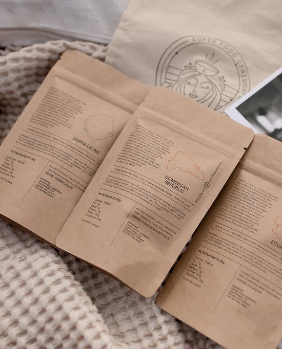 Drie zakjes ceremoniële cacao: Sierra Leone, Dominicaanse Republiek en Ecuador. Bruin verpakt met gouden tekst en logo.