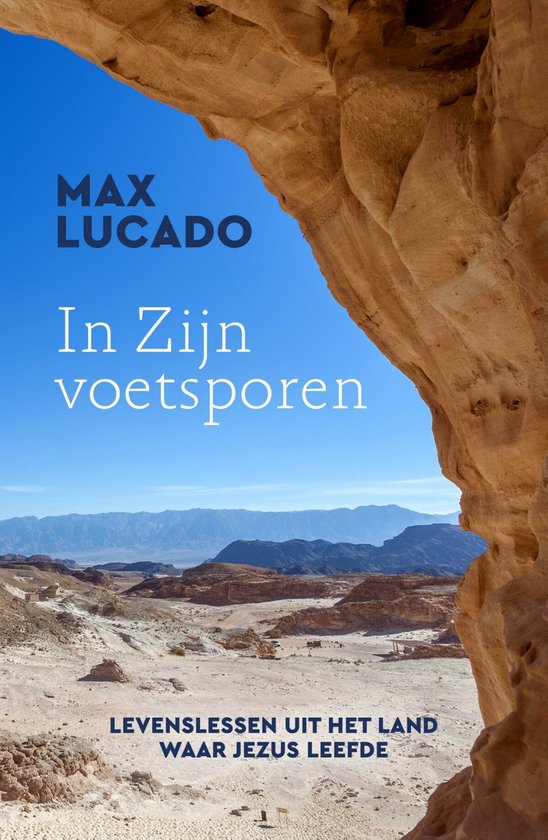 Boek 'In zijn voetsporen' met op de cover een rotsformatie met uitzicht op een bergachtig, droog landschap. Tekst: MAX LUCADO In Zijn voetsporen LEVENLESSEN UIT HET LAND WAAR JEZUS LEEFDE.