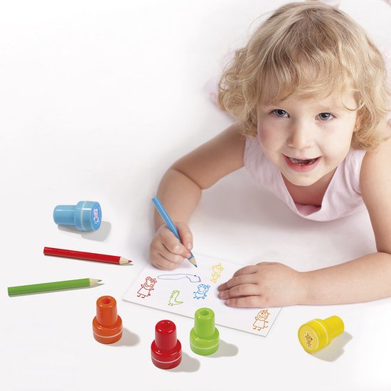Een jong meisje met blond haar ligt op de grond en kleurt met een blauwe potlood, Peppa Pig stempels liggen op de tafel.