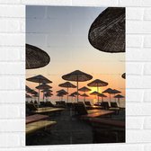 WallClassics - Muursticker - Strand met Ligbedden en Rieten Parasols - 50x75 cm Foto op Muursticker