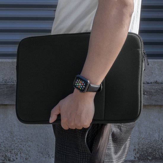 Man met zwarte laptophoes en smartwatch