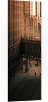PVC Schuimplaat- Twee overlopende Gebouwen in een donkere Stad - 50x150 cm Foto op PVC Schuimplaat