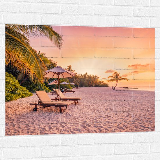 Muursticker - Luxe Ligbedden op Wit Strand tijdens Feloranje Zonsondergang - 100x75 cm Foto op Muursticker