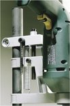 Detailopname van een boorstandaard met groene boormachine, close-up van het klemmechanisme.