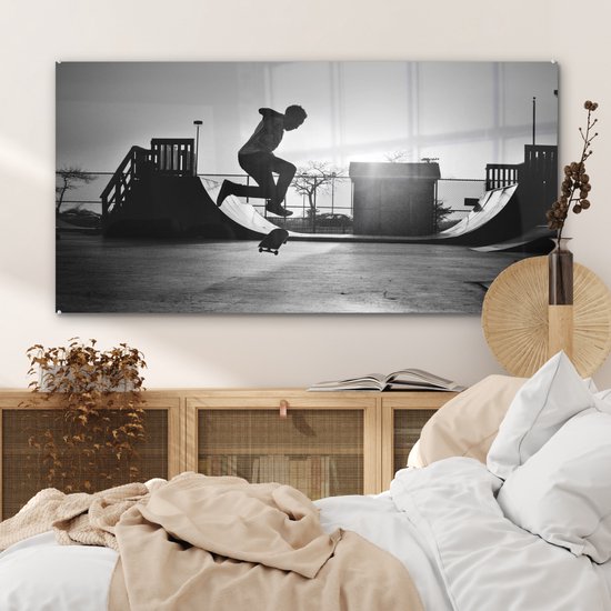 Peinture sur verre MuchoWow® - Un garçon fait une cascade avec son skateboard pendant le coucher du soleil - noir et blanc - 120x60 cm - Peintures sur verre acrylique - Photo sur Glas