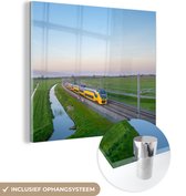 MuchoWow® Glasschilderij 90x90 cm - Schilderij acrylglas - Een trein rijdt door een landschap - Foto op glas - Schilderijen