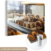 MuchoWow® Glasschilderij 60x40 cm - Schilderij acrylglas - De gebakken broodjes in de etalage van de bakker - Foto op glas - Schilderijen