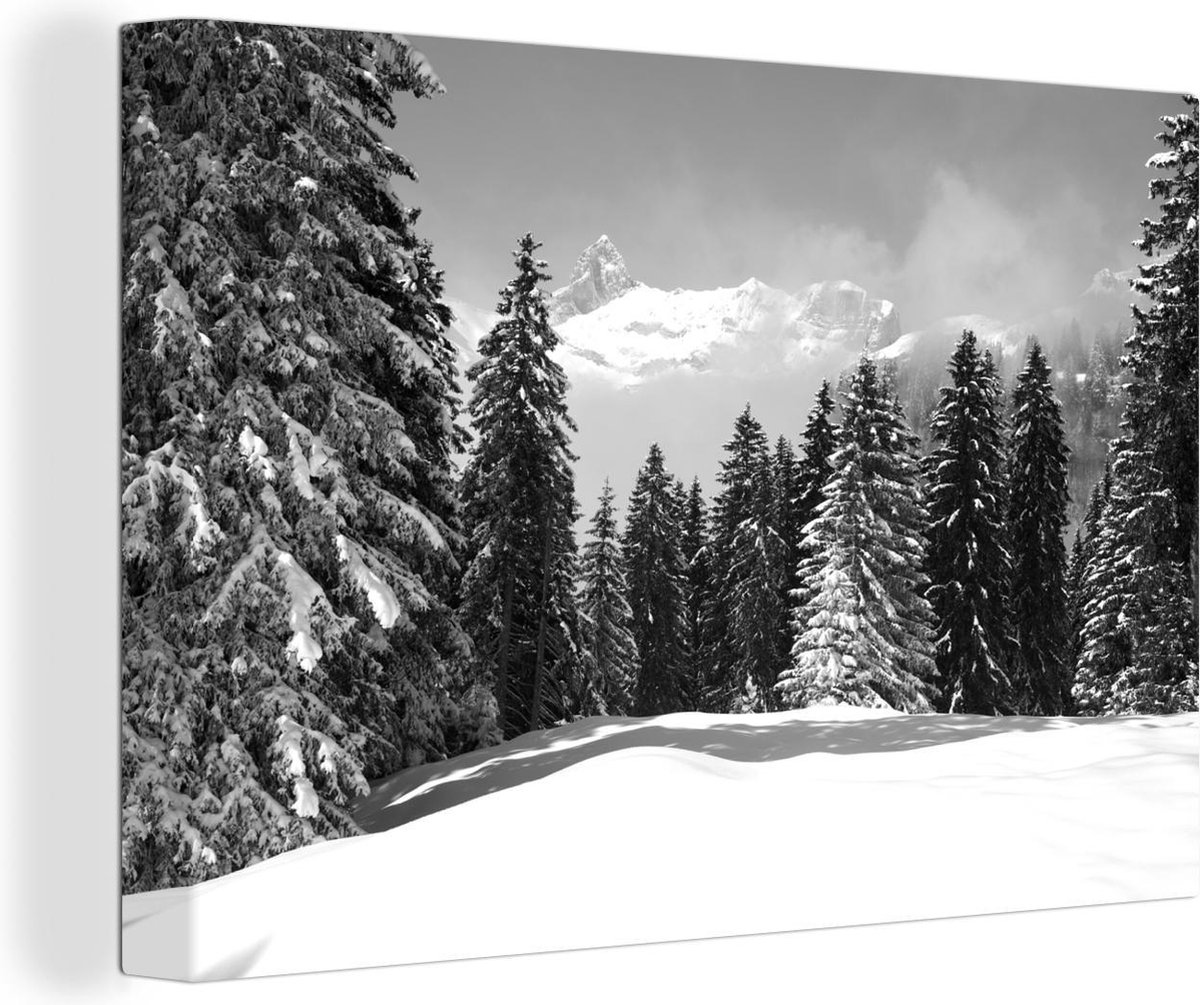 Canvas Schilderij De besneeuwde bomen in de bergen zorgen voor een kerstsfeer - zwart wit - 90x60 cm - Wanddecoratie