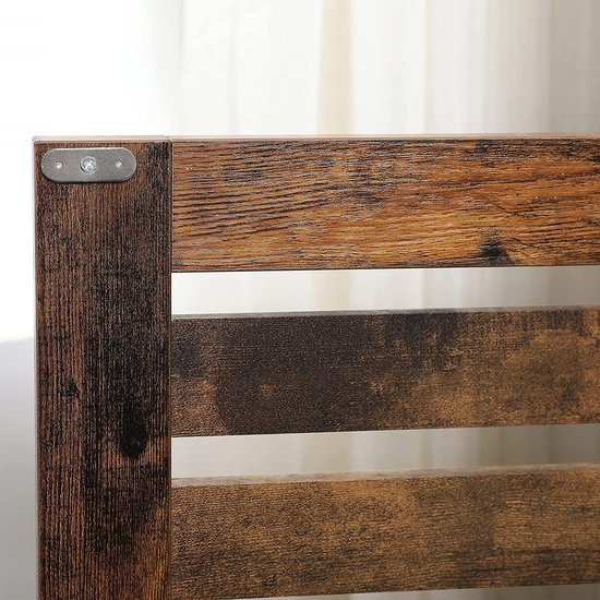 Detail van bruine houten spijlen met metalen bevestiging aan de zijkant.