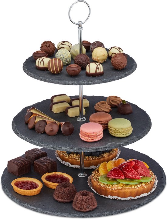 Drie-laags leistenen etagère gevuld met diverse chocolades, macarons, gebakjes en taartjes.