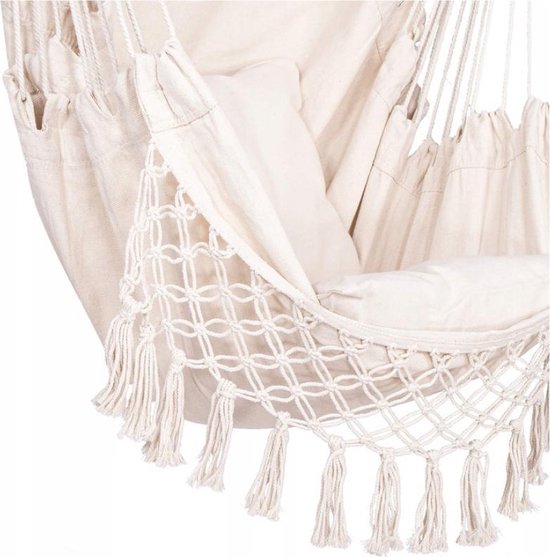 Detail van de witte hangstoel met macramé, franjes en kussens.