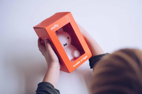 Kinderhanden houden een Miffy-lampje in oranje 'bundle of light' verpakking vast.