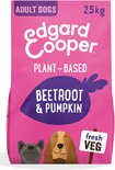 Een roze zak Edgard & Cooper hondenvoer 'Plant-Based Beetroot & Pumpkin'. Twee honden, een Franse Bulldog en een bruine hond, kijken vrolijk.