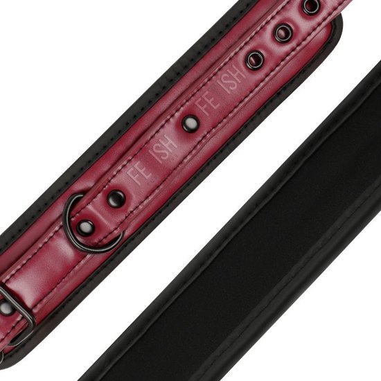 Detail van rode vegan leren polsband met metalen ogen, gesp en 'FETISH SUBMISSIVE' opdruk.