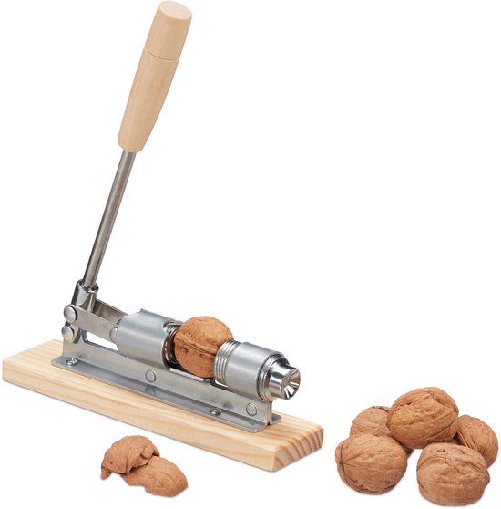 Casse-noix en métal et bois, avec une noix à l'intérieur, et une pile de noix à côté.