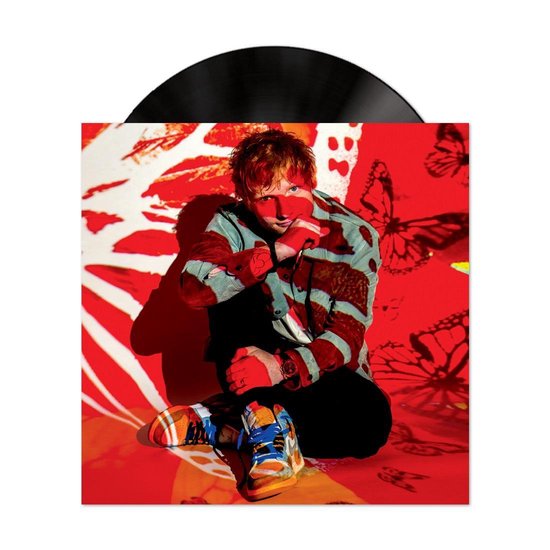 Zwart vinyl met albumhoes. Ed Sheeran zit op de grond met rode projecties van vlinders op zijn gezicht en kleding. Hij draagt een gestreepte blouse en kleurrijke sneakers.