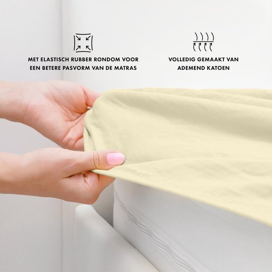 Crème hoeslaken met elastische band, tonen hoe de stof wordt uitgerekt om de matras te bedekken.