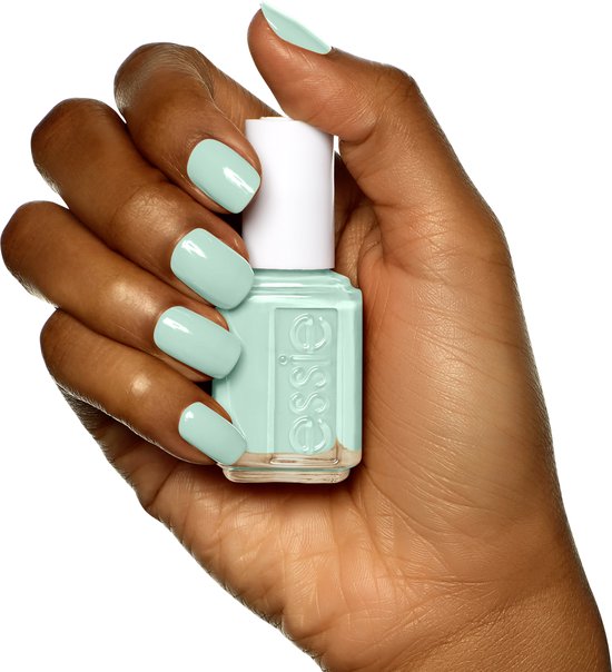 Hand met mintgroene Essie nagellak, houdt een flesje Essie nagellak vast.