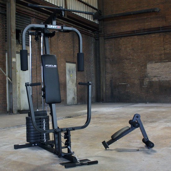 Zwart Focus Fitness Unit 2 krachtstation met losse leg curl unit in een magazijn.