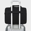 Zwarte laptoptas op de handgreep van een koffer, met een band aan de achterkant om hem vast te zetten.
