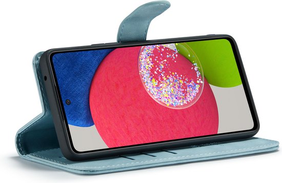 Aqua blauw Casemania telefoonhoesje opengeklapt, met telefoon met kleurrijke achtergrond.